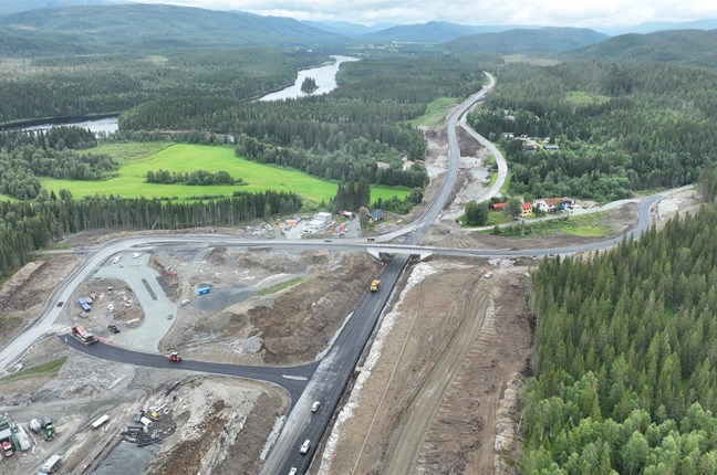 Bildet viser et dronefoto over det nye krysset ved Grøndalselv, hvor man kan se at asfaltering pågår på sidevegen som er fylkesveg 764. 