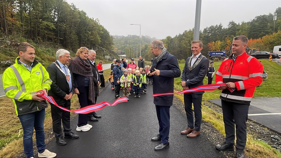 Her klipper samferdselsminister Jon-Ivar Nygård snora over den nye gang- og sykkelvegen til stor glede for mange fornøyde barn fra Solkollen Hånes barnehage.