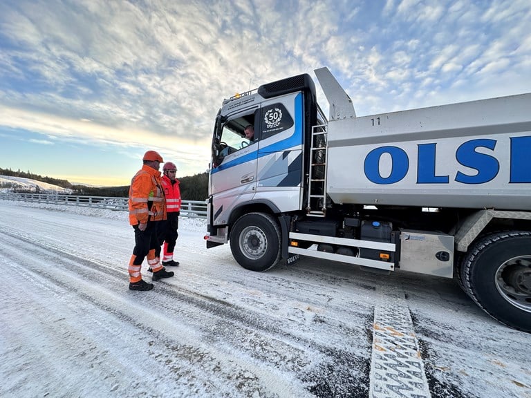 Bildet viser Arild Olsbakk som sitter i bilen, mens Per Arne Sønmør, anleggsleder i Johs. Syltern og Stig Johansen, byggeleder i Vegvesenet står utenfor. 