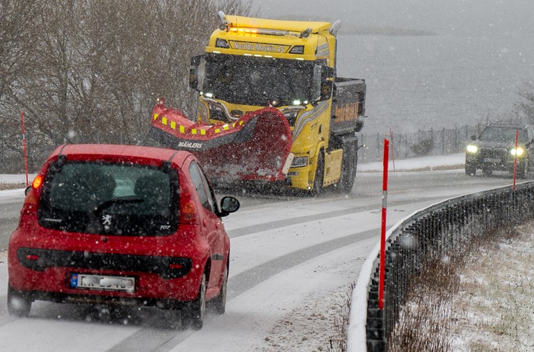 Kulda kan gi glatt føre på Sørlandet denne helga. Bildet viser snødekt veg, brøytebil og personbiler.