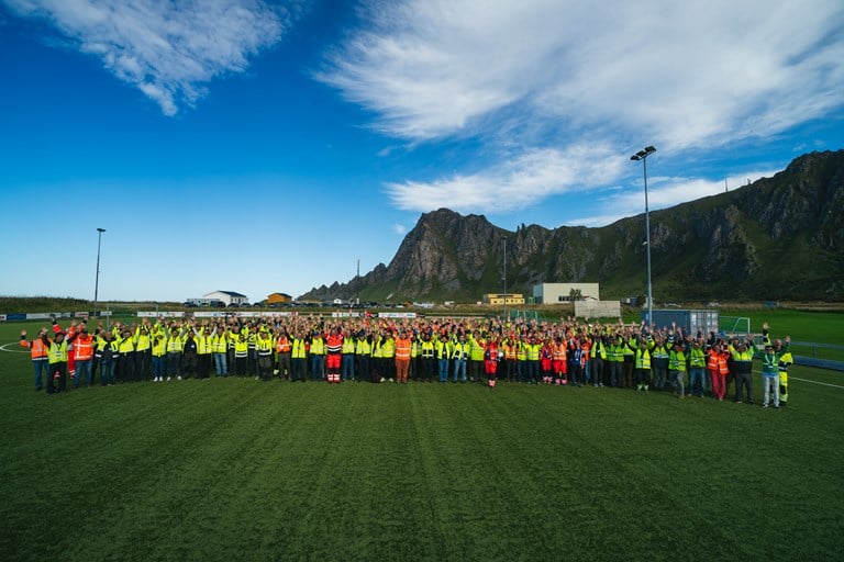 Mange mennesker som står på en fotballbane og ser mot fotografen.