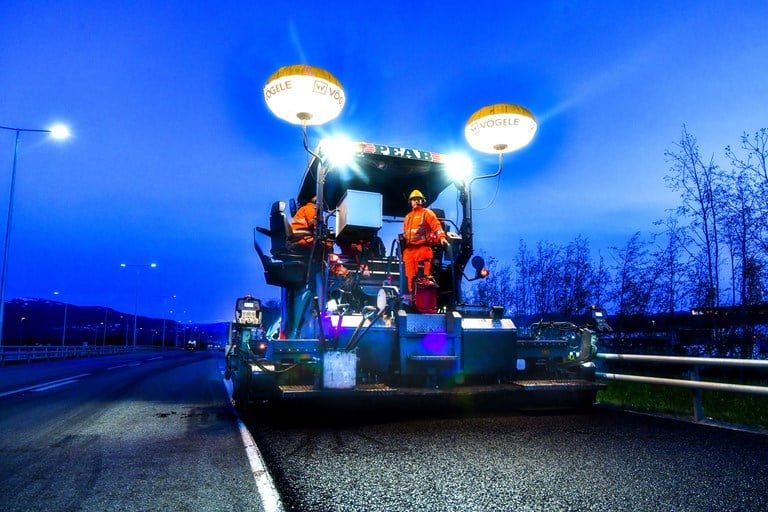 Bilde av asfalteringsmaskin som arbeider i skumringen. Foto: Knut Opeide/Statens vegvesen.