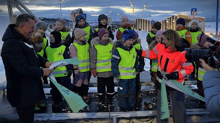 Bildt viser William Herold Hansen fra trinn 1. ved Workinnmarka skole i Tromsø som fikk æren av å klippe snora og markere at Giæverbukta bussterminal var offisielt åpnet. Til venstre ordfører i Tromsø, Gunnar Wilhelmsen (Ap), til høyre vegdirektør Ingrid Dahl Hovland, Statens vegvesen.