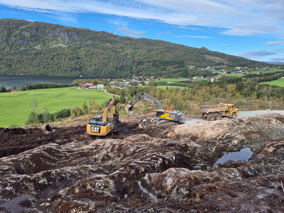 Graving og avdekking av fjell som skal sprenges på strekninga. Nå er det full aktivitet på anlegget. To gravemaskiner og en dumper i arbeid.