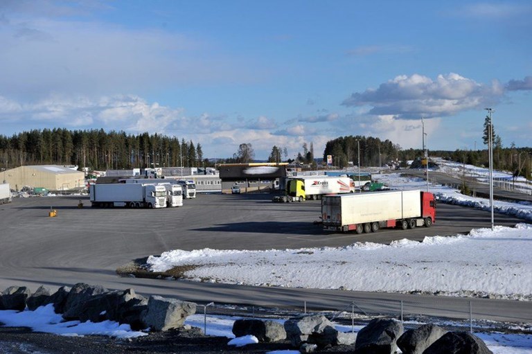 Lastebiler står parkert på en asfaltert plass.