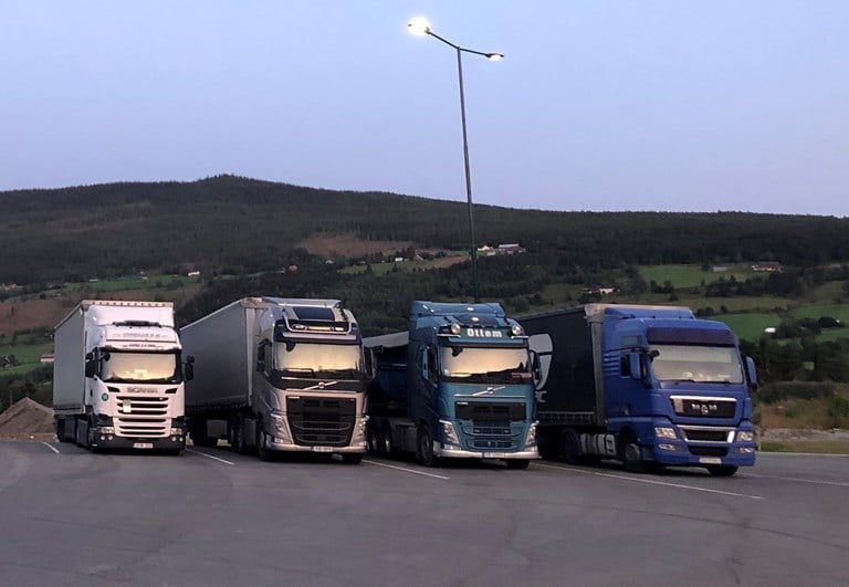 Fire lastebiler står parkert ved siden av hverandre med fronten mot kameraet.